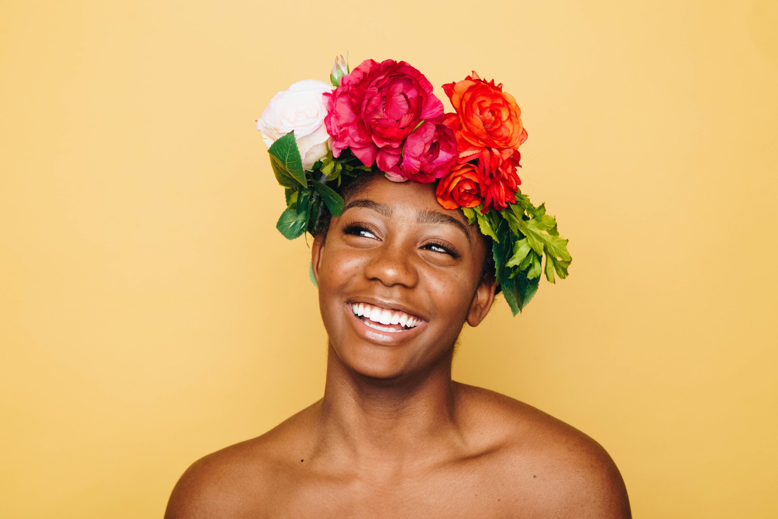 Smiling black lady with perfect teeth. Patients compare same day crowns vs traditional crowns, but both produce equal results. 