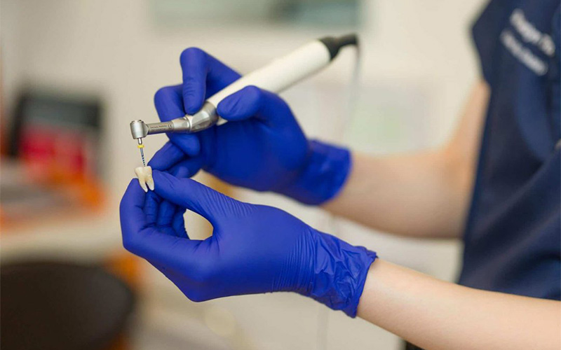 Elite Dental dentist performing a root canal treatment in Singapore.