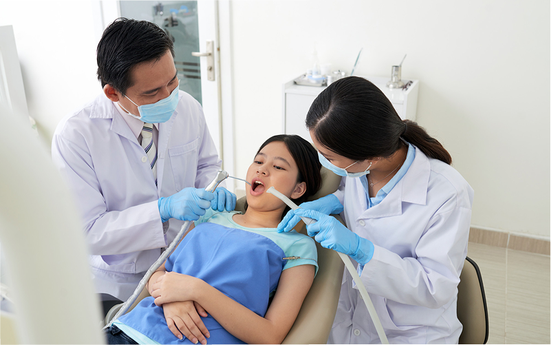 Dentists performing a gentle checkup for patient.