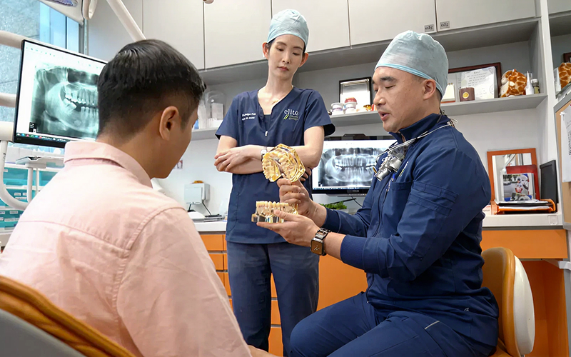Dental professional using a model to explain gum repair.