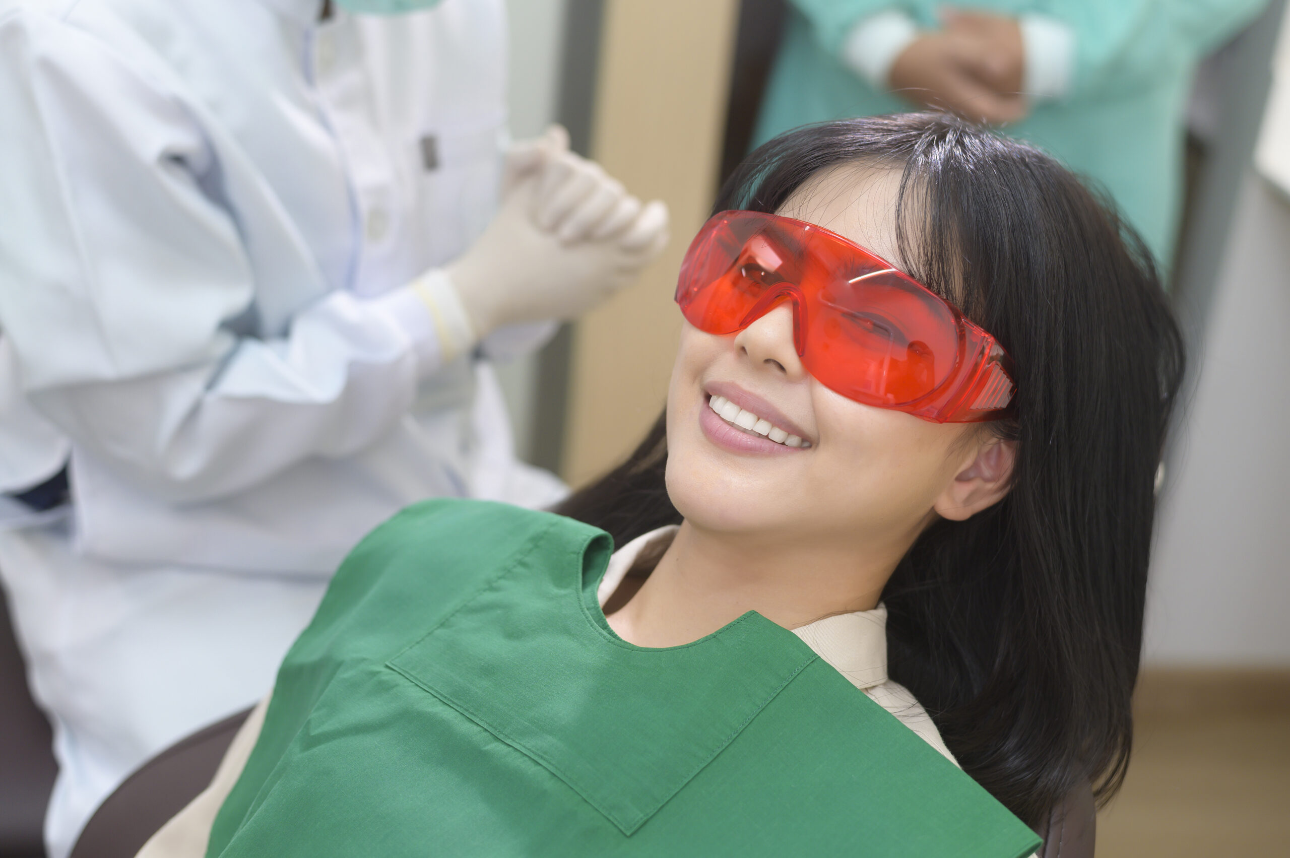 Dental patient with protective glasses and bib.